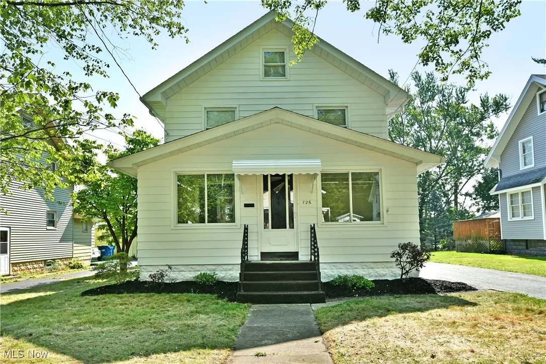 American foursquare style home with entry steps and a front yard