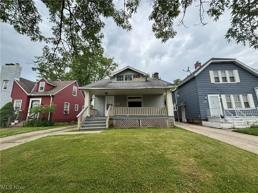 View of front facade with a porch, driveway, and a front yard