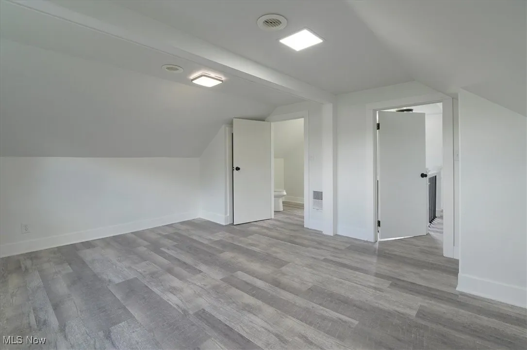 Additional living space with vaulted ceiling and wood finished floors