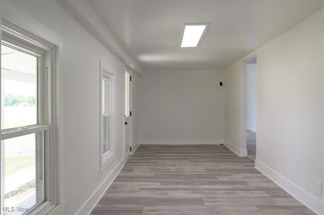 Hall featuring plenty of natural light and wood finished floors