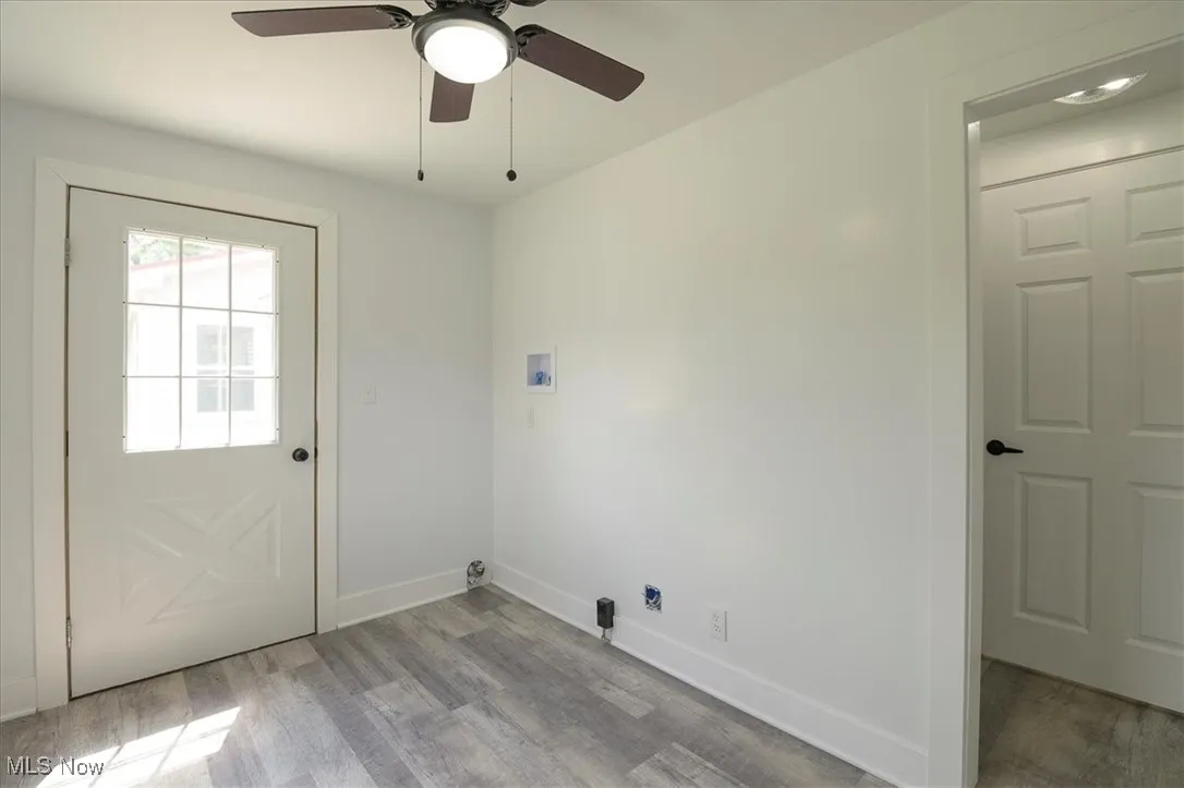 Laundry room featuring wood finished floors, hookup for a washing machine, and a ceiling fan