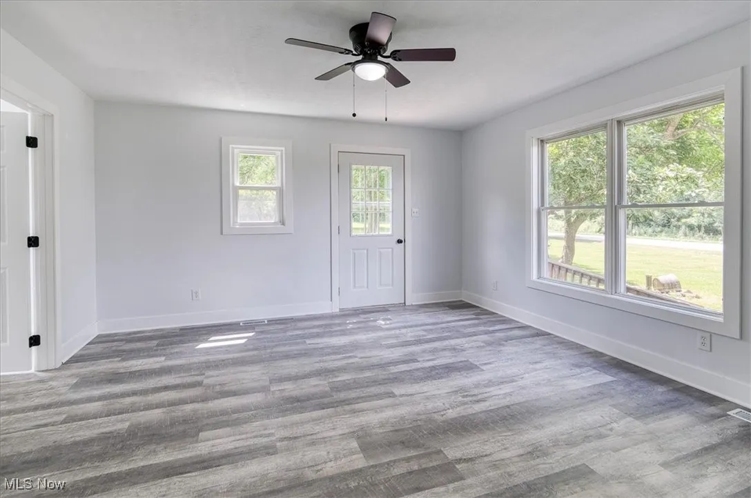 Unfurnished room with wood finished floors and ceiling fan