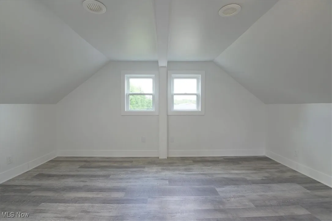 Bonus room with lofted ceiling and wood finished floors