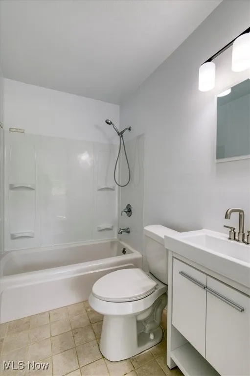 Full bath featuring vanity, bathing tub / shower combination, and tile patterned flooring