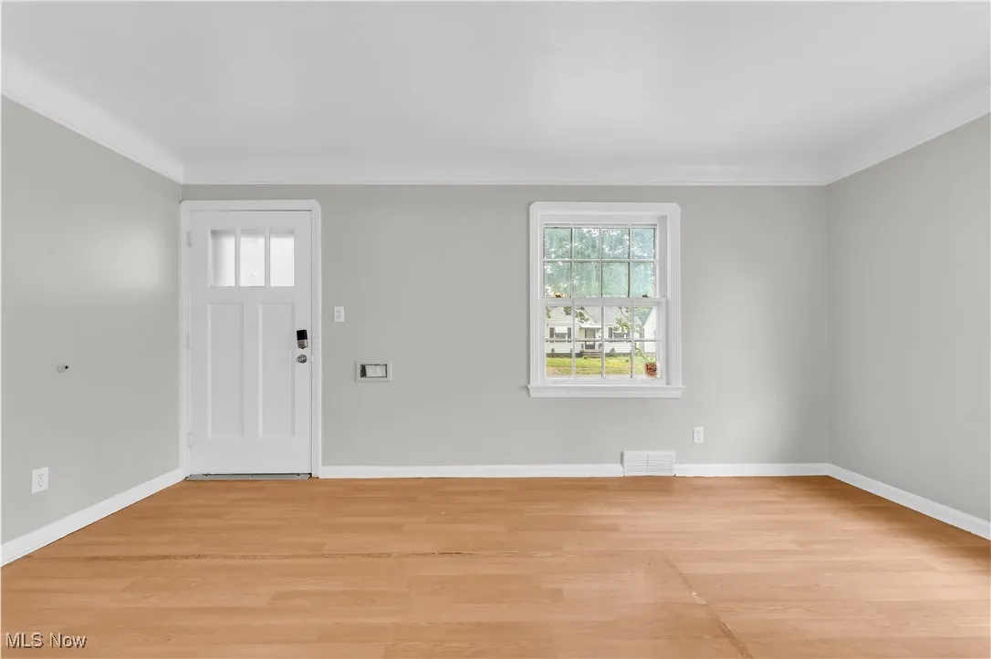 Entrance foyer featuring light wood finished floors and ornamental molding