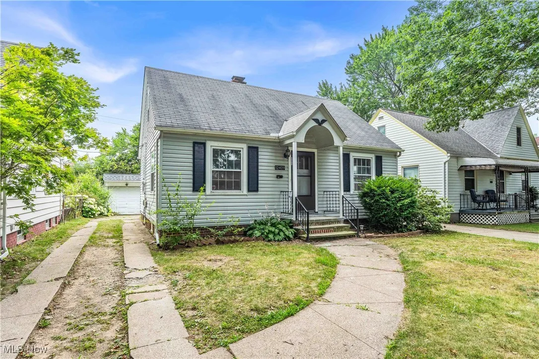 View of front of property featuring a shingled roof and a front yard