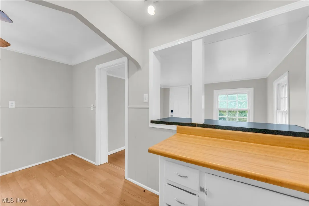 Kitchen featuring light wood-type flooring and white cabinets