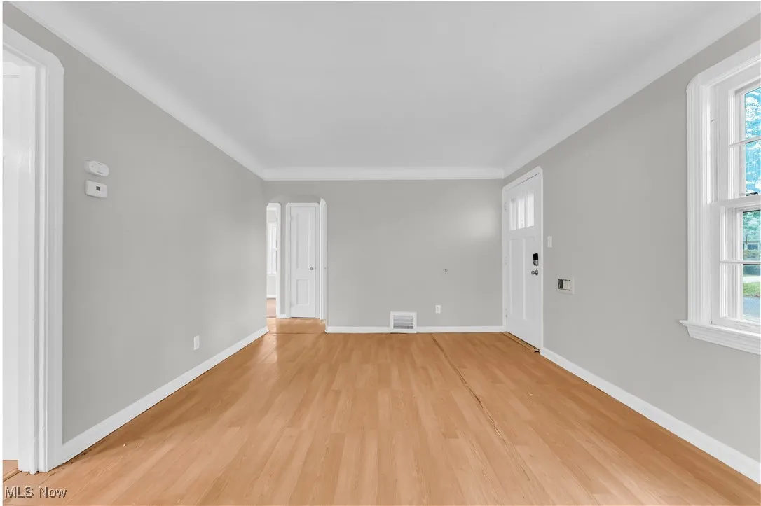Unfurnished living room featuring light wood finished floors and arched walkways
