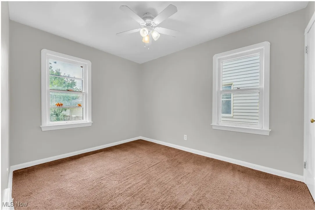 Spare room with carpet floors and a ceiling fan