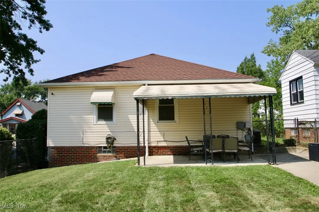 Back of house with a patio and roof with shingles