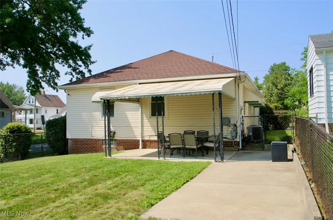 Back of house with a patio and a shingled roof