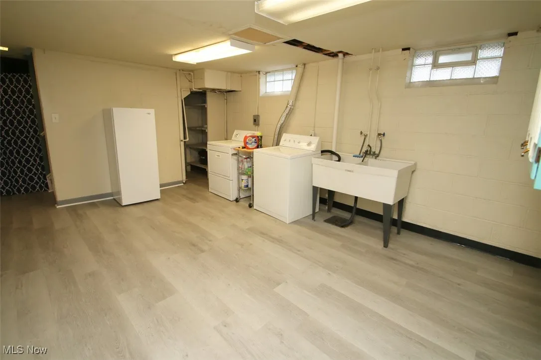 Laundry area featuring washer and dryer, light wood-style flooring, and healthy amount of natural light