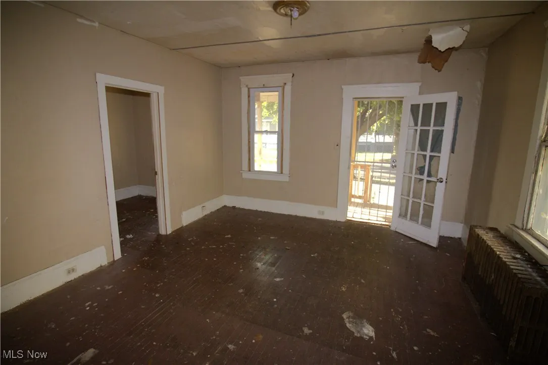 Empty room with radiator heating unit and wood finished floors