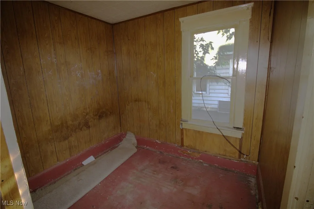 Empty room featuring wood walls