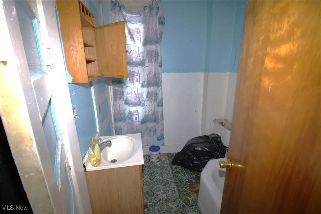 Bathroom with vanity, a bathtub, and curtained shower
