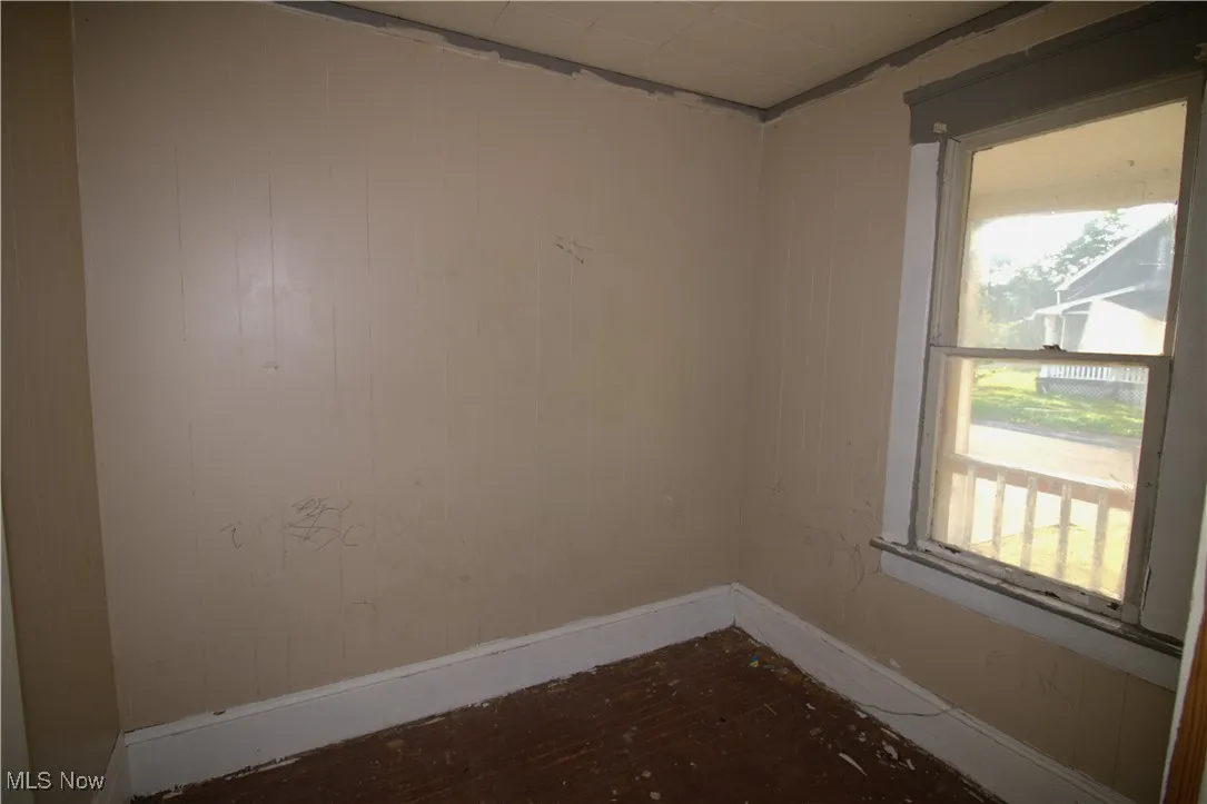 Empty room with healthy amount of natural light and wood finished floors