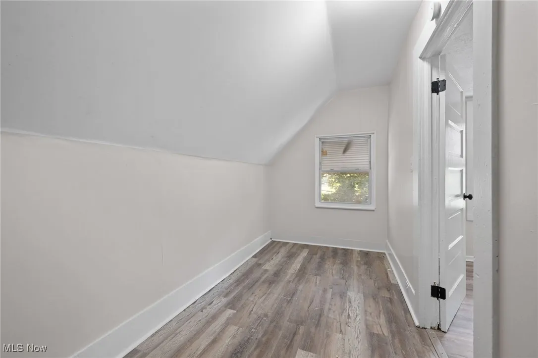 Bedroom featuring lofted ceiling and wood style floors