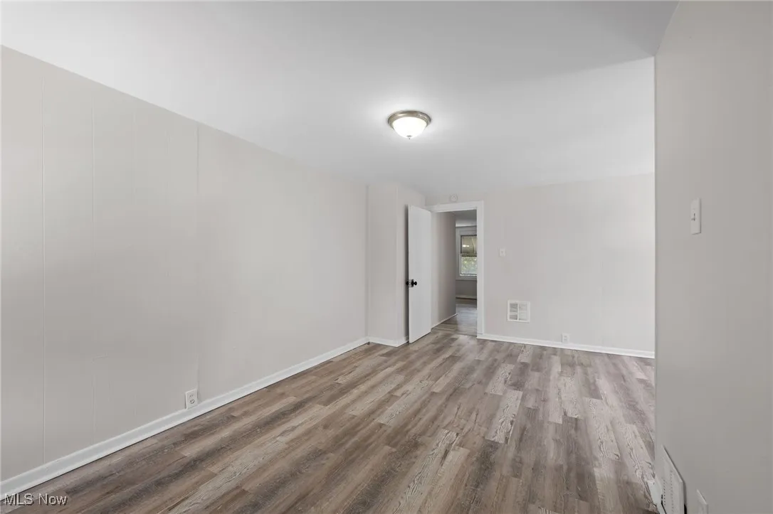 Unfurnished room with wood style floors and baseboards