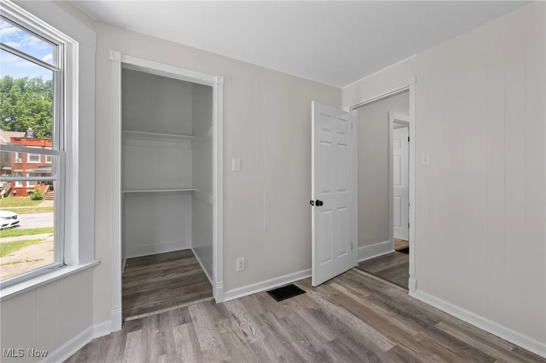 Unfurnished bedroom featuring wood style floors and multiple windows