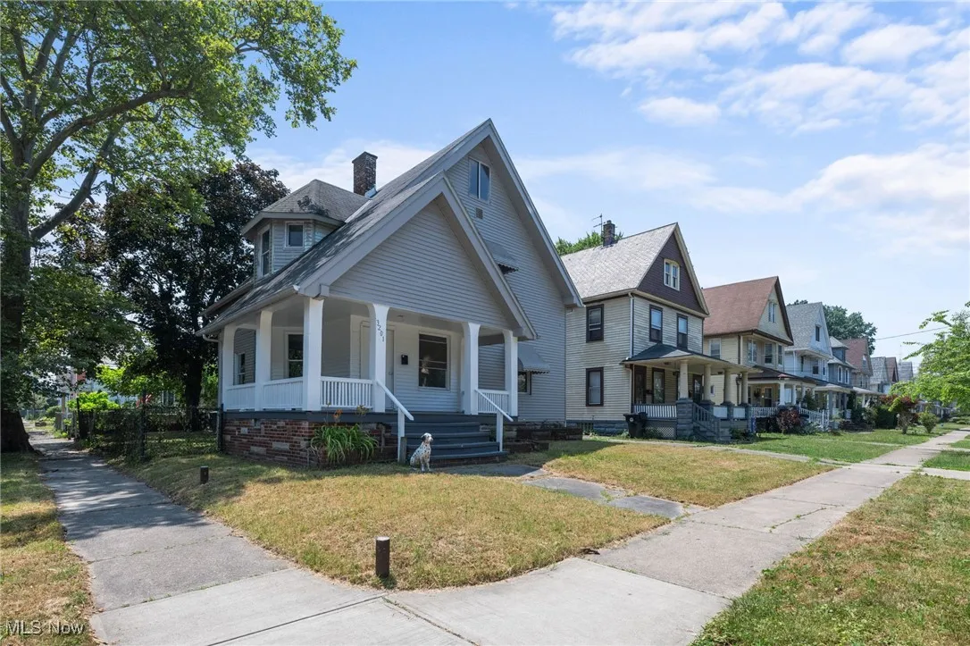 View of front of property with a porch, and a front yard