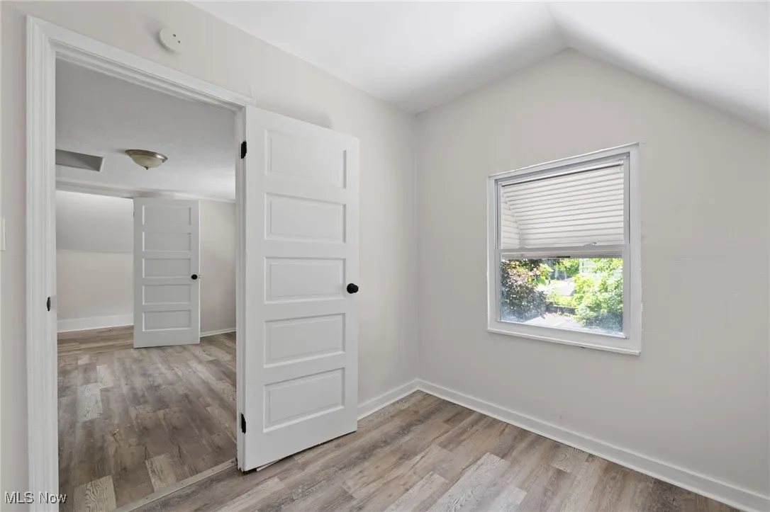 Bedroom with wood style floors and vaulted ceiling