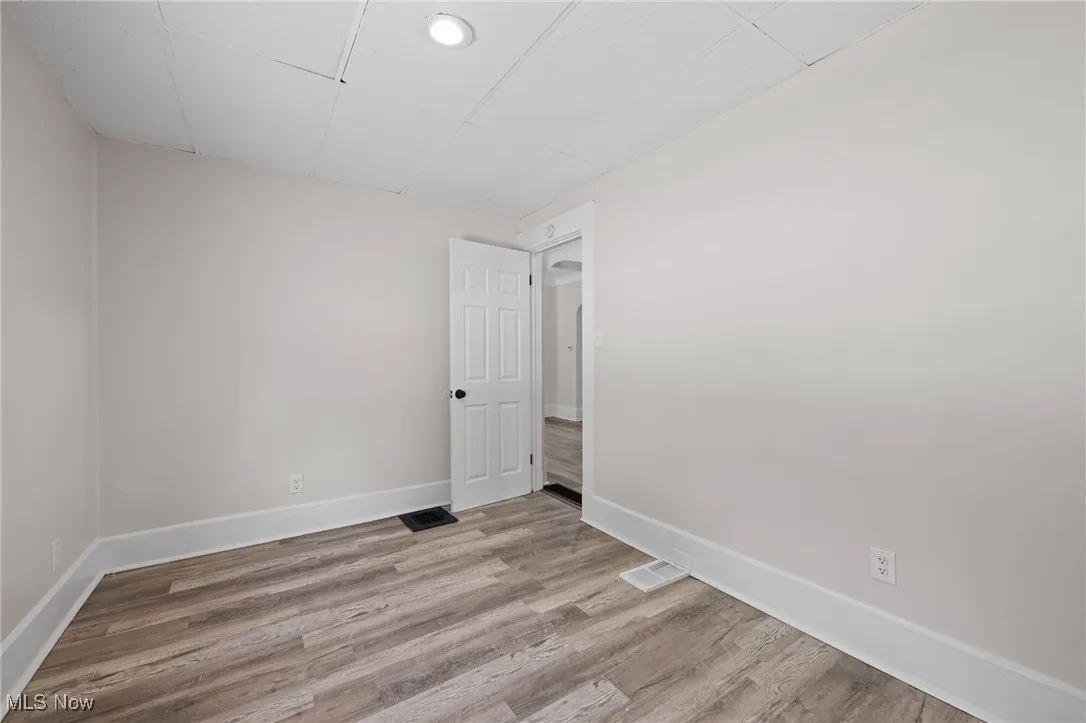 Bedroom with wood style floors and baseboards