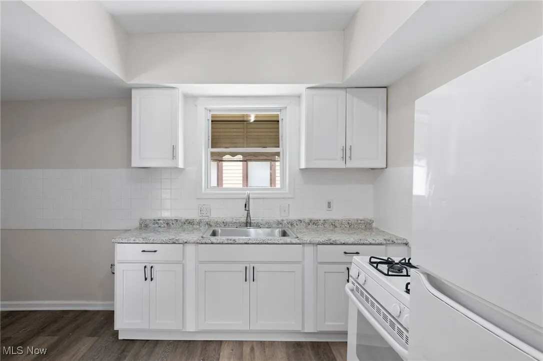 Kitchen with white appliances, white cabinets, and light countertops