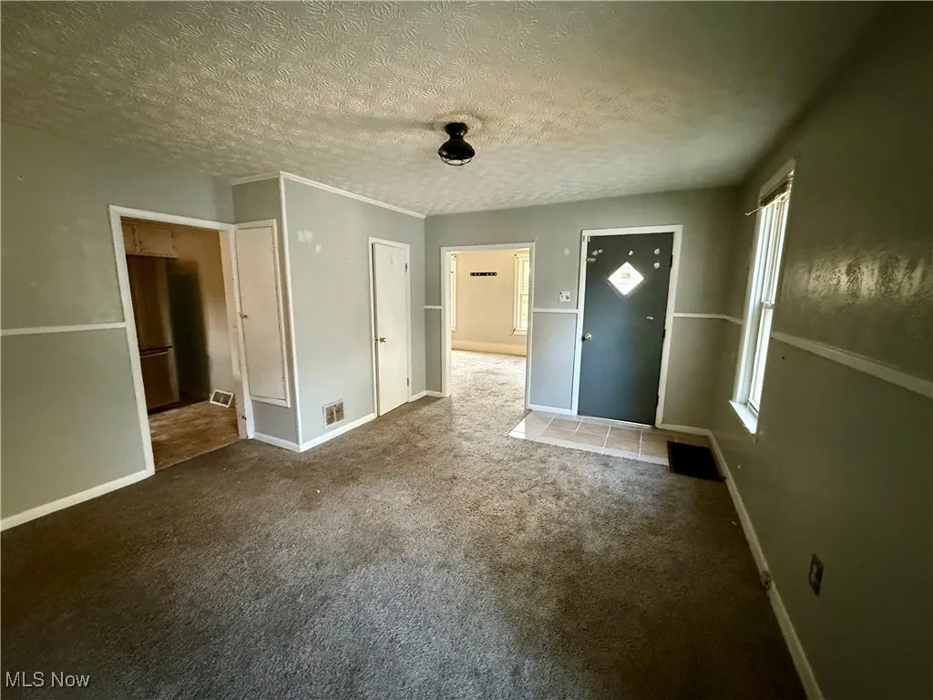 Unfurnished bedroom with carpet and a textured ceiling