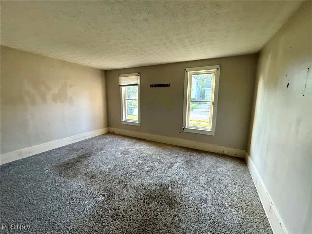 Empty room featuring carpet floors and a textured ceiling