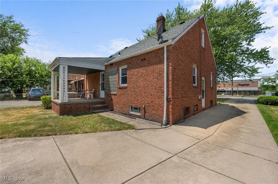 View of front of house with brick siding, a porch, a chimney, a shingled roof, and concrete driveway