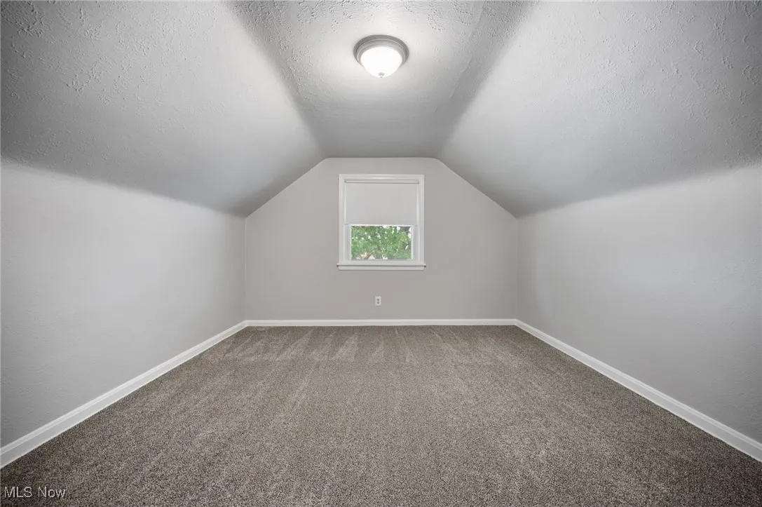 Bedroom with carpet, vaulted ceiling