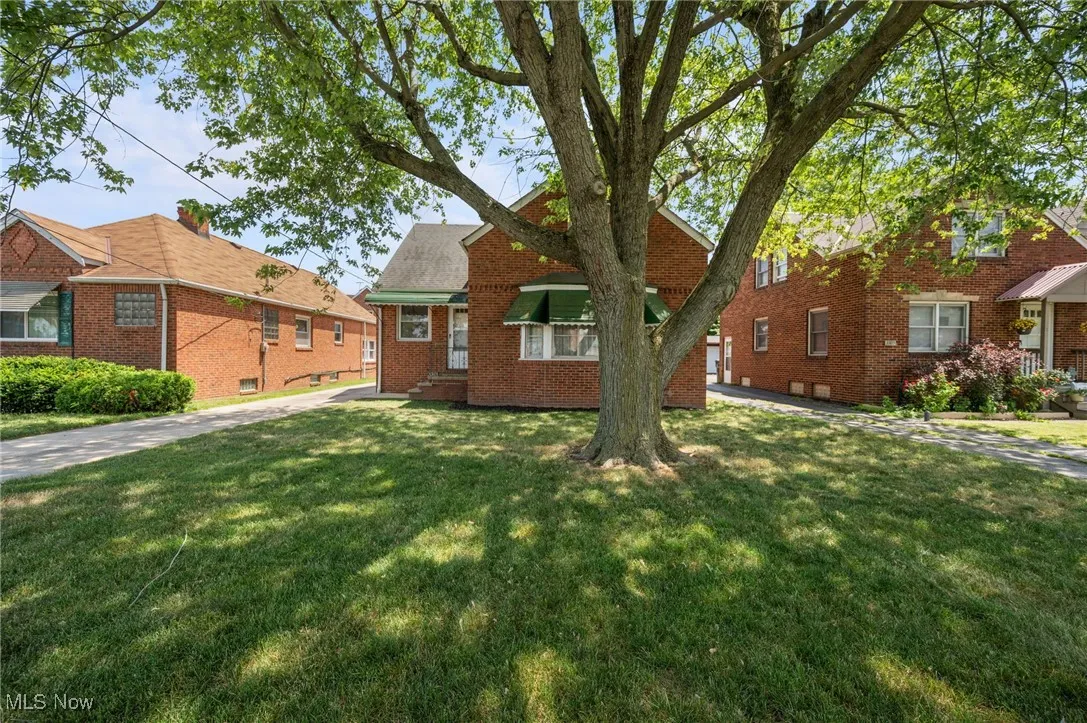 View of property exterior featuring a yard and brick siding