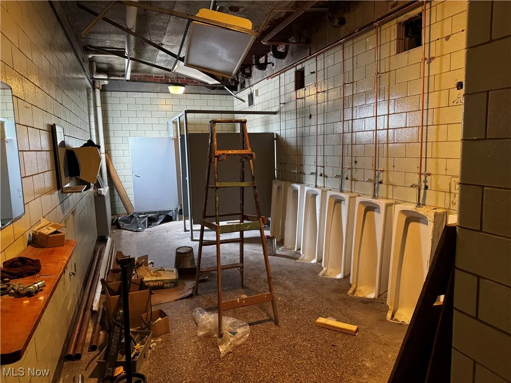 Miscellaneous room featuring tile walls