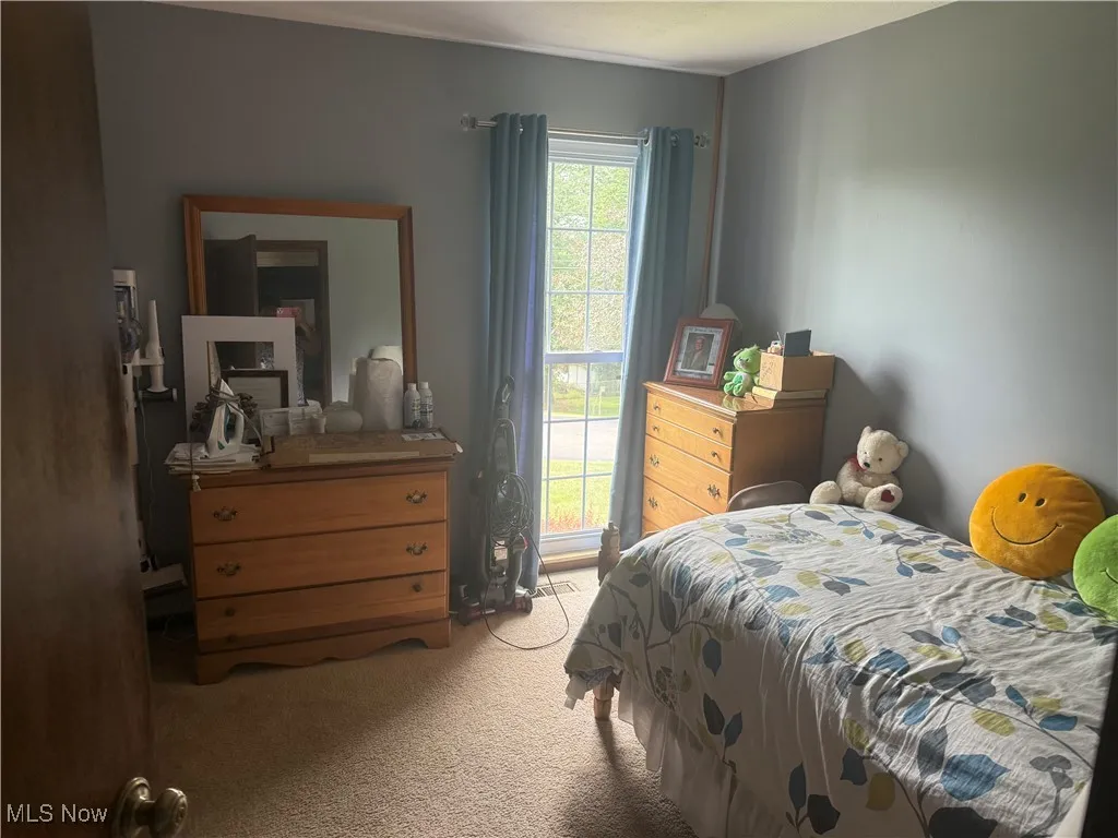 Bedroom featuring light colored carpet
