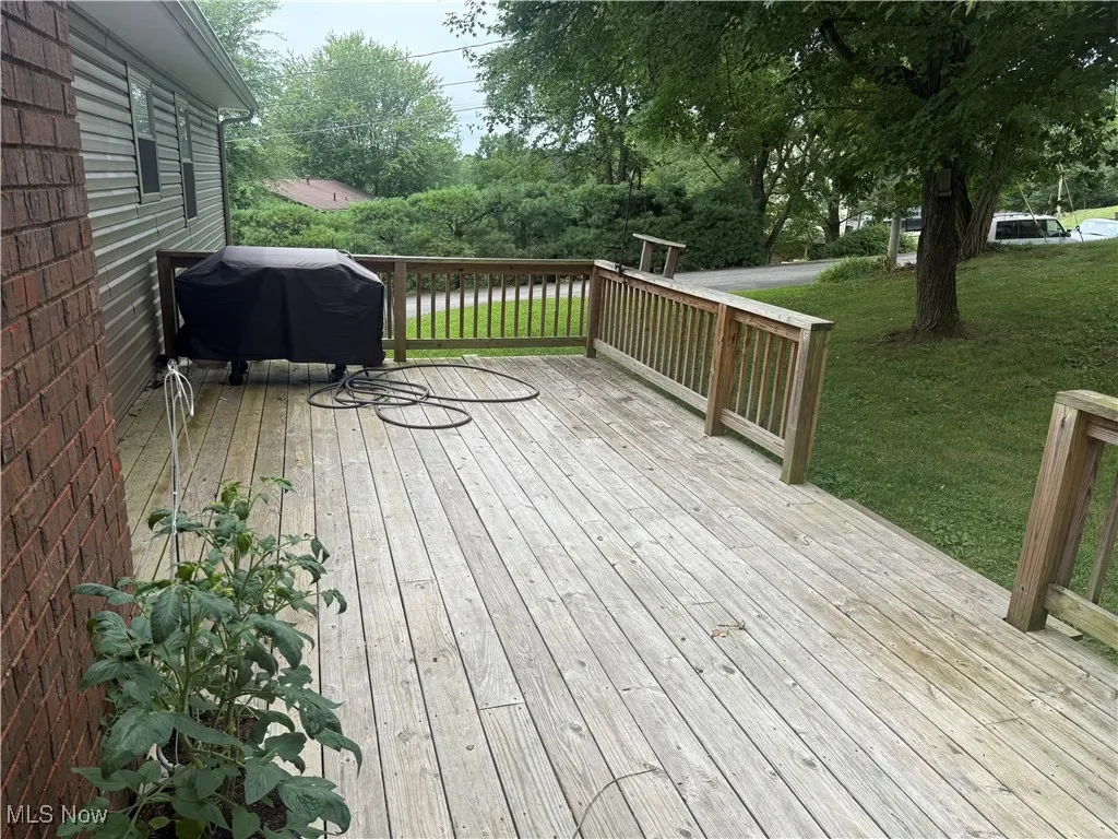 Wooden deck with a yard and a grill