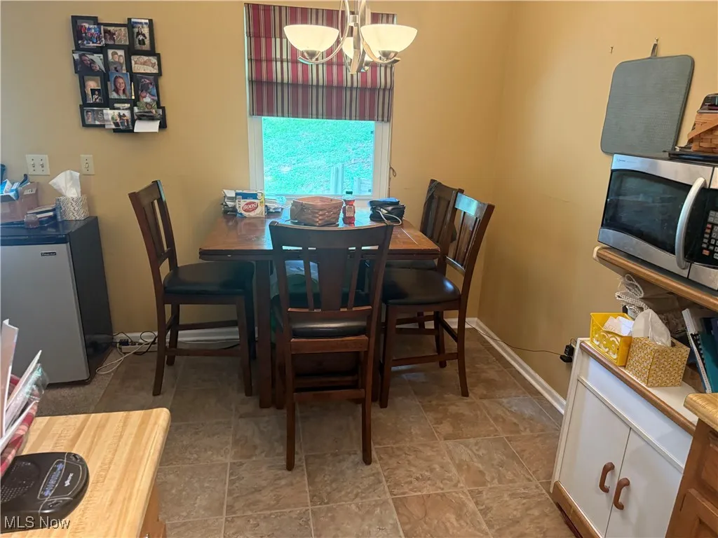 Dining space featuring a chandelier and baseboards