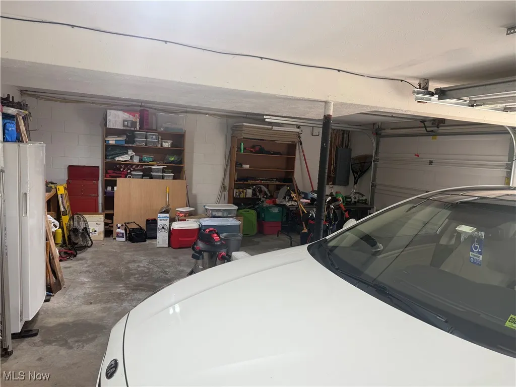 Garage featuring concrete block wall and electric panel