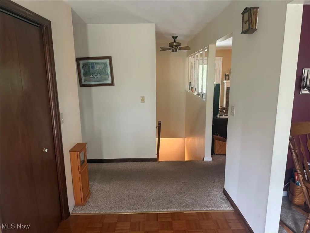 Hall featuring an upstairs landing and carpet floors