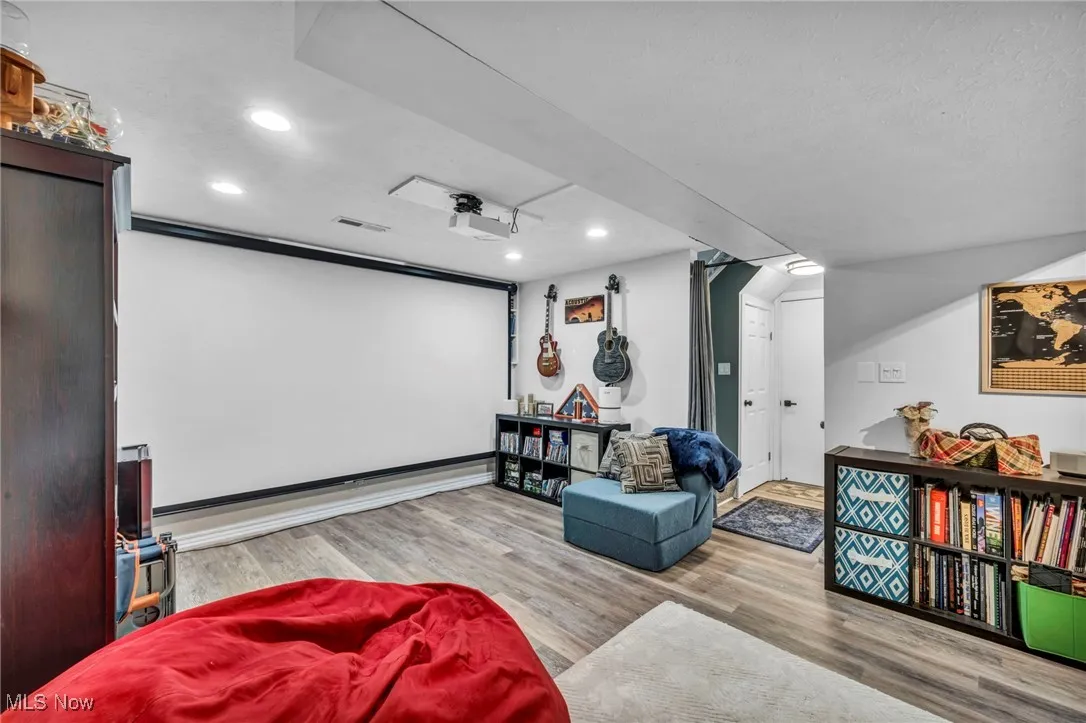 Home theater room with wood finished floors and recessed lighting