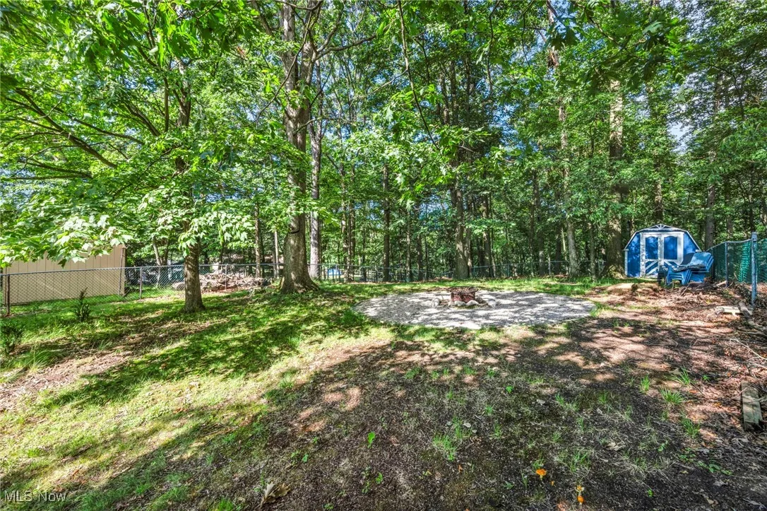 Fenced backyard featuring a storage shed