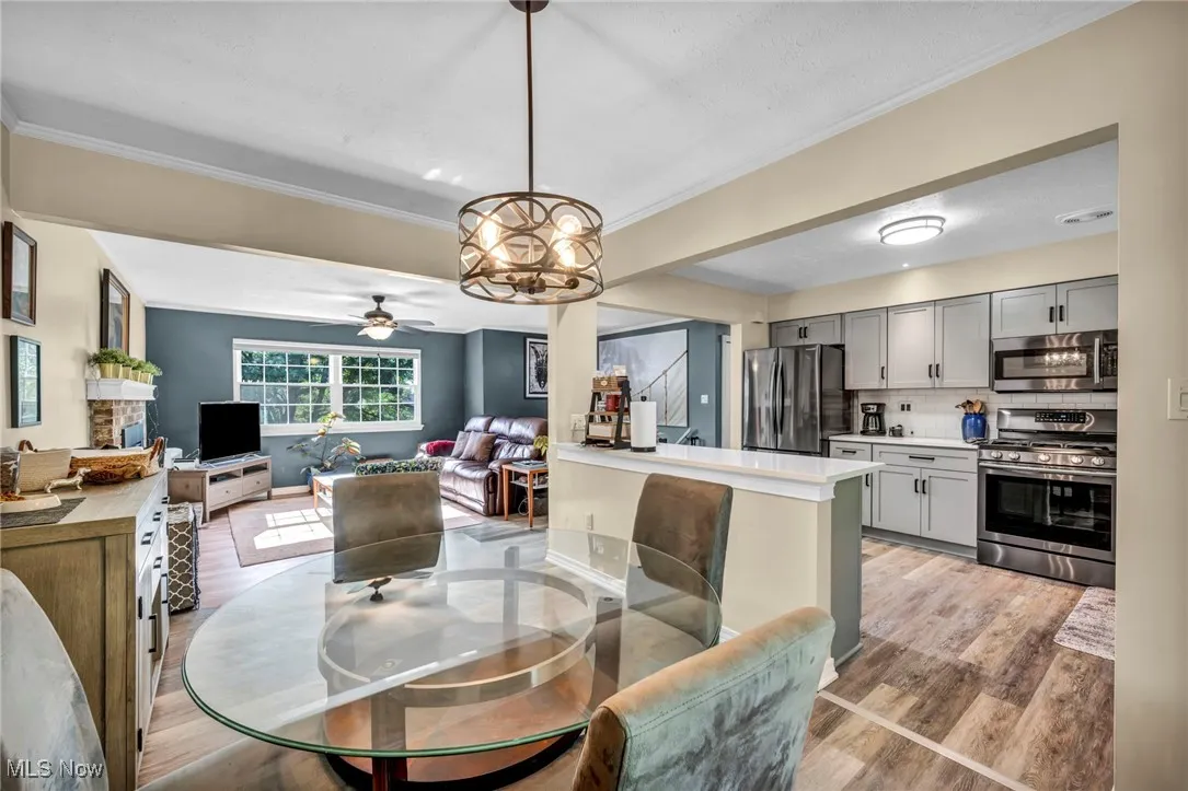 Dining area featuring light wood-type flooring, a ceiling fan, and ornamental molding