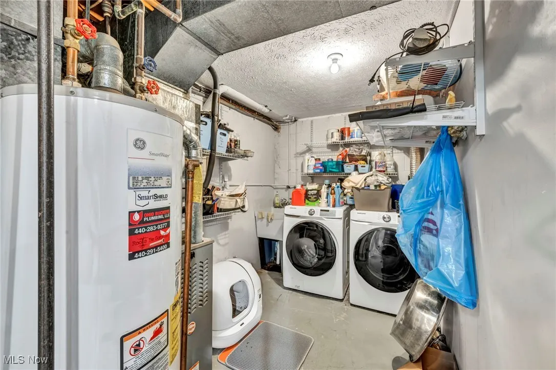 Washroom featuring gas water heater and washer and clothes dryer