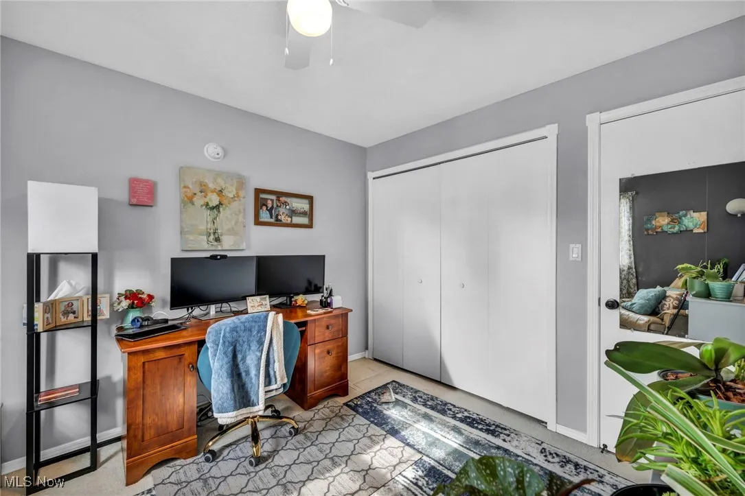 Home office with ceiling fan and baseboards