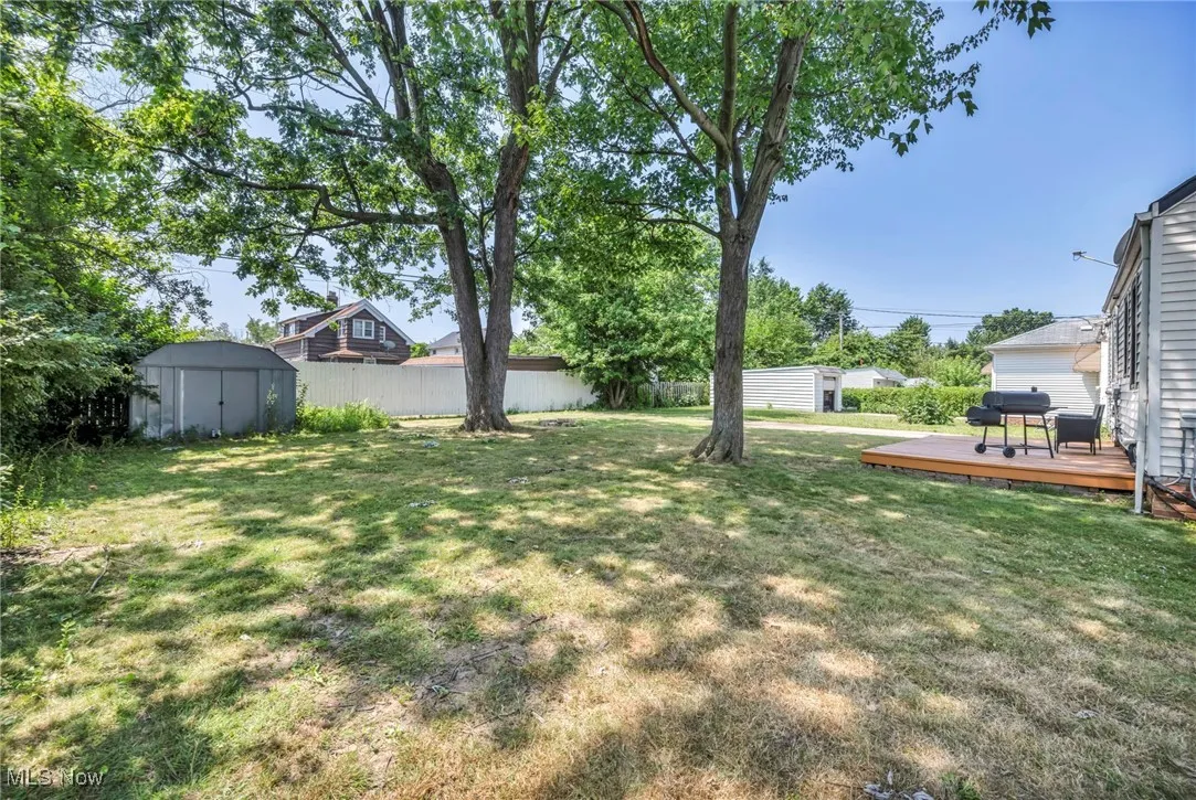View of yard featuring a storage unit and a wooden deck