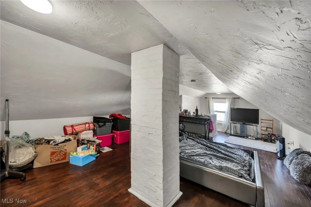 Bedroom with vaulted ceiling and hardwood / wood-style flooring