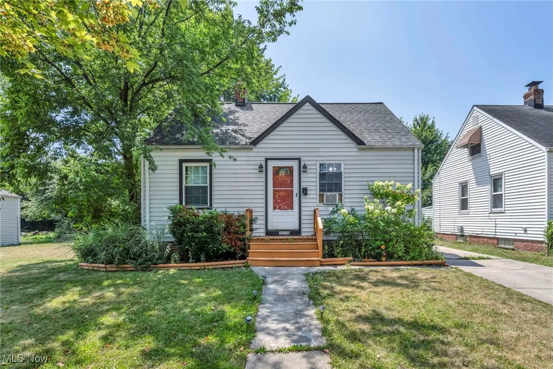 View of front of property featuring a front yard and roof with shingles