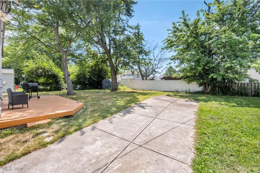 Fenced backyard with a deck and a storage unit