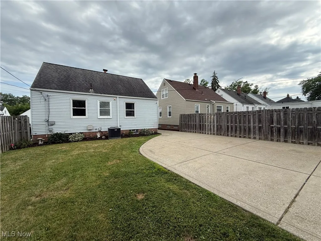 Back of property with roof with shingles and a patio