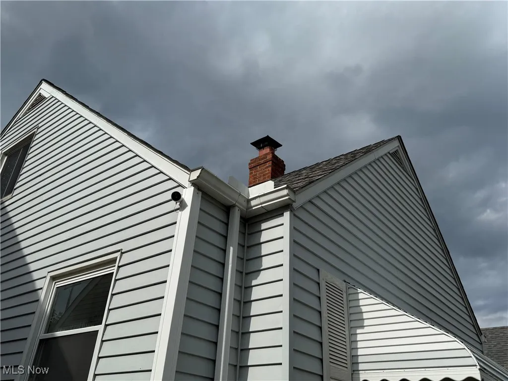 Exterior view of a chimney and roof with shingles