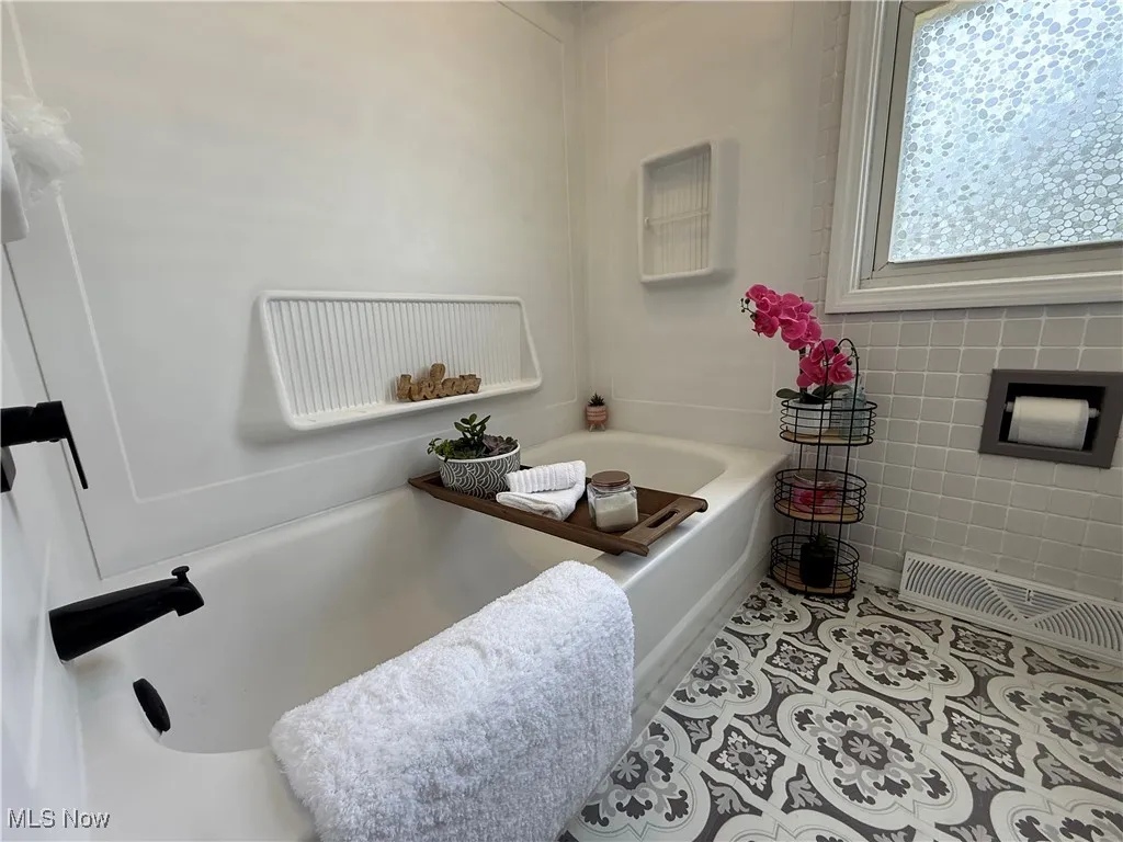 Bathroom with a garden tub and tile walls